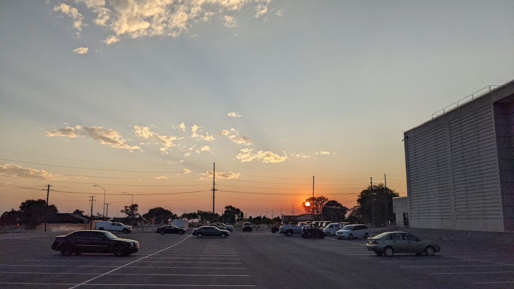 From my parking lot at work, sun rays, clouds, and the sun peeking through the trees.